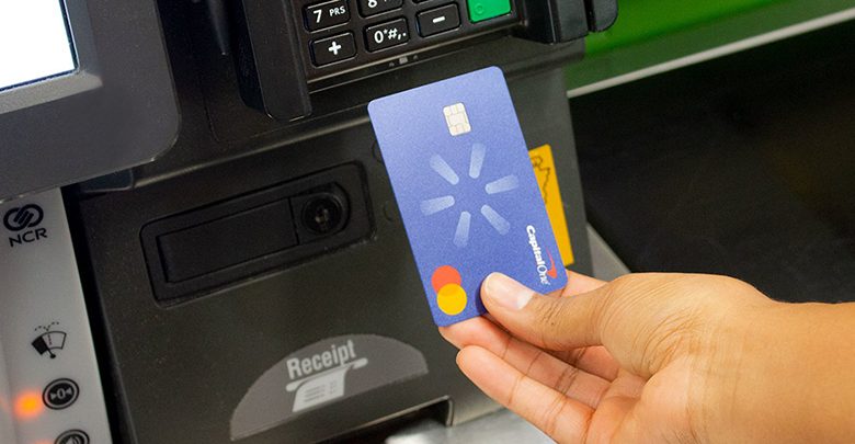 a woman uses the new capital one walmart rewards card