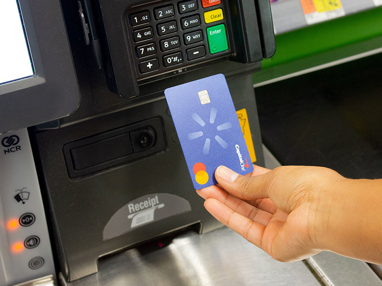 a woman uses the new capital one walmart rewards card