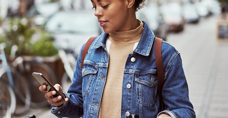 a woman looks at a financial app on her phone