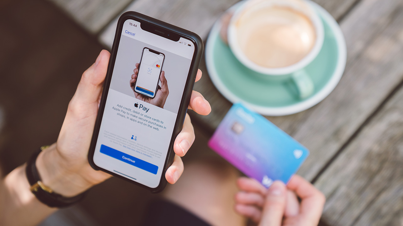 a woman pays for coffee with her digital wallet