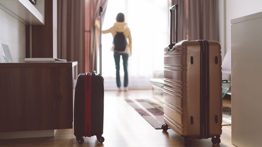 luggage rests on the floor of a hotel room