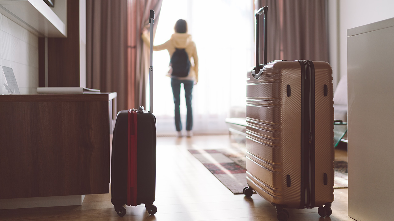 luggage rests on the floor of a hotel room
