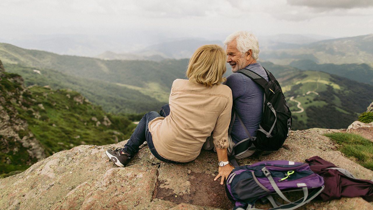 a mature couple cuddle during a hike