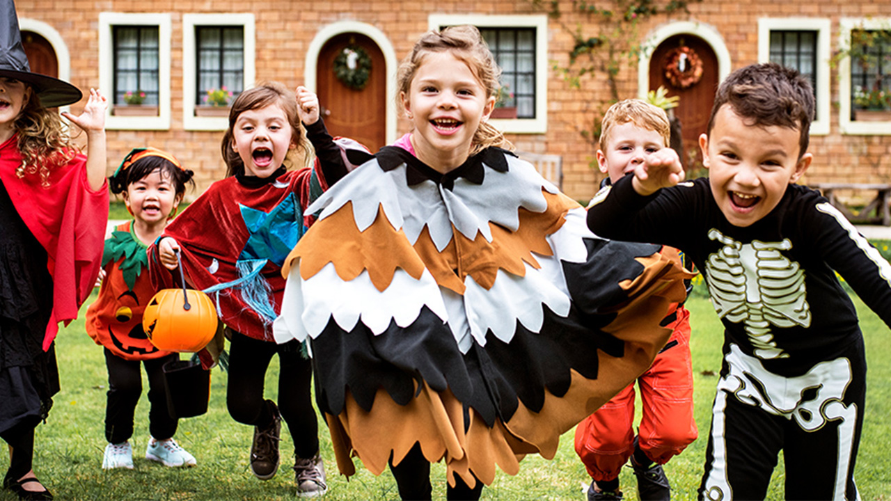 kids in halloween costumes race towards the camera
