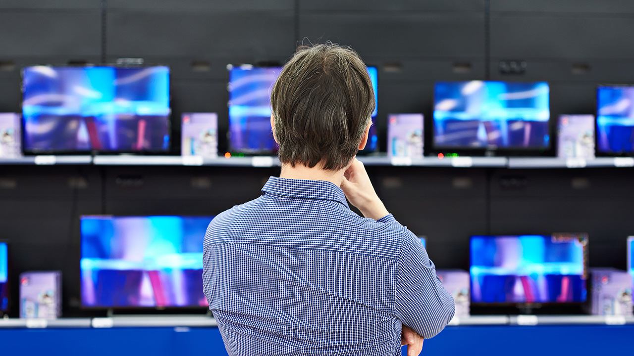 a man chooses a television in a store
