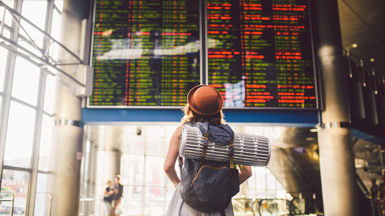 traveler looks at departure screen at airport