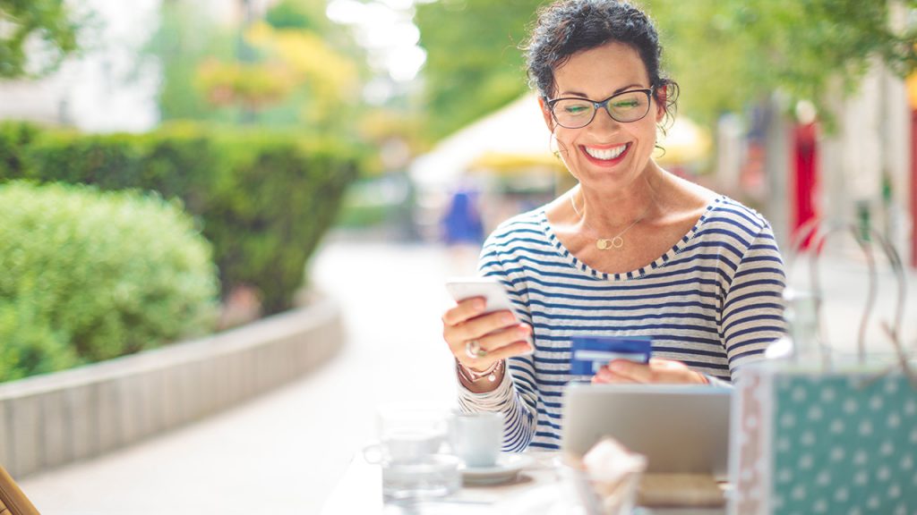 a happy woman with a laptop and credit card