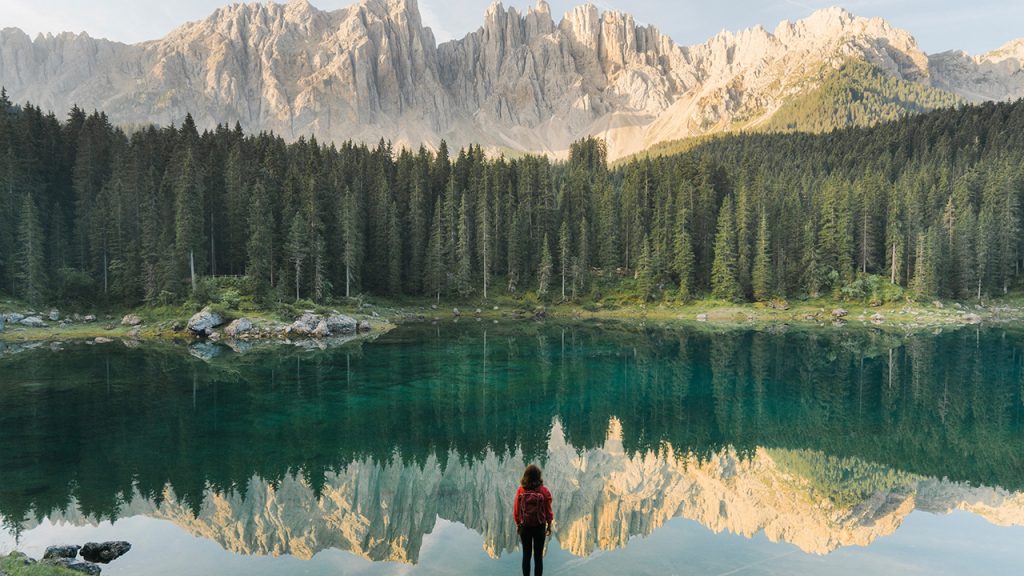 woman stands in front of a mountain