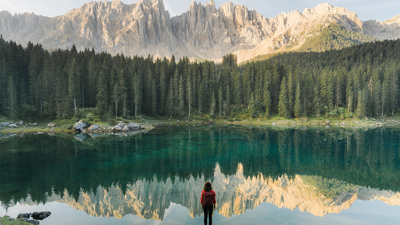 woman stands in front of a mountain