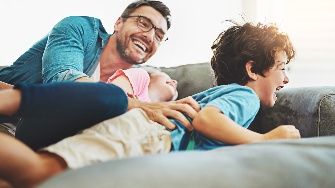 a family laughs together on the couch