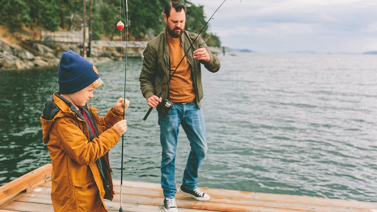 Father and son fish at a lake