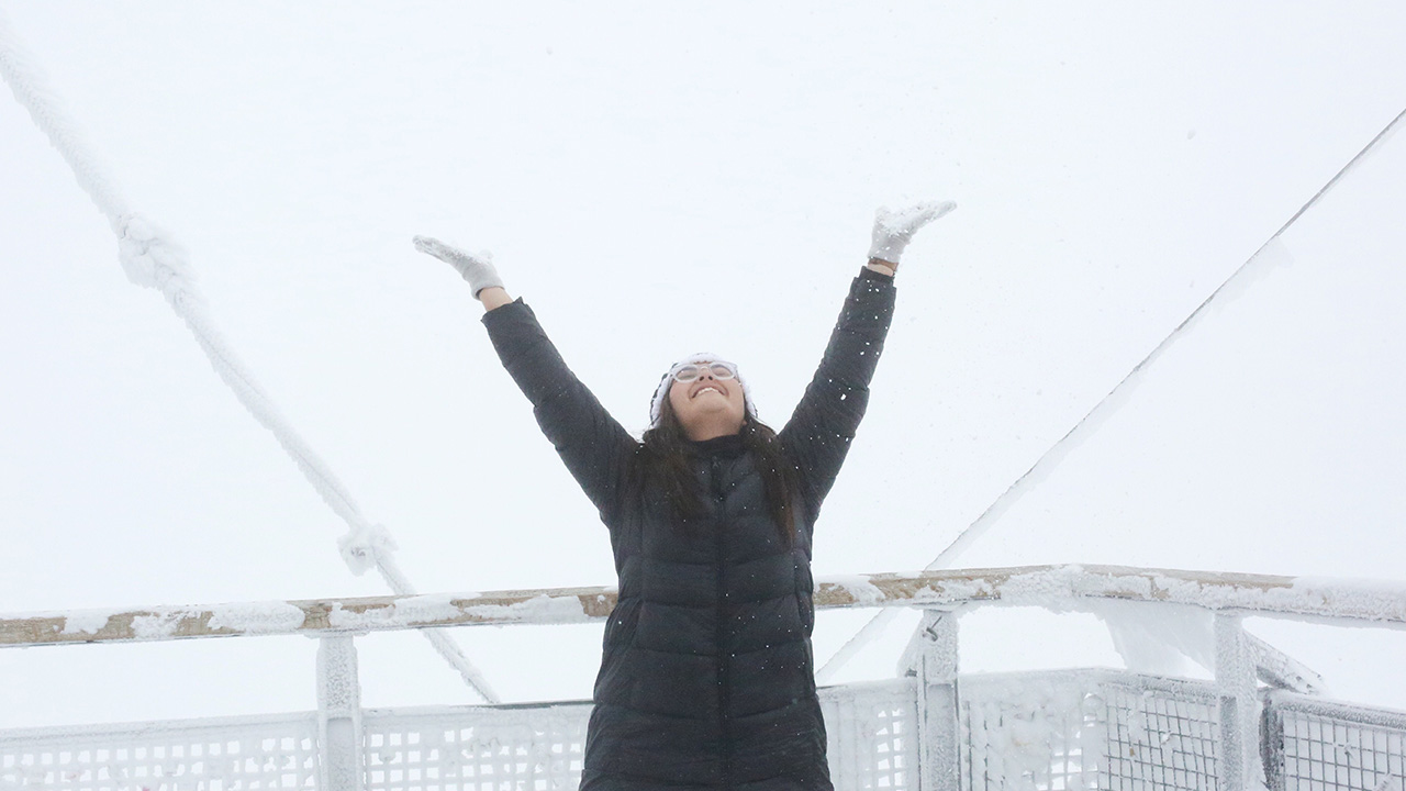 woman celebrates on a ship during cold weather