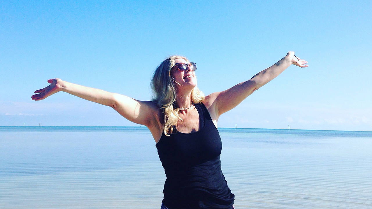 smiling woman poses outdoors