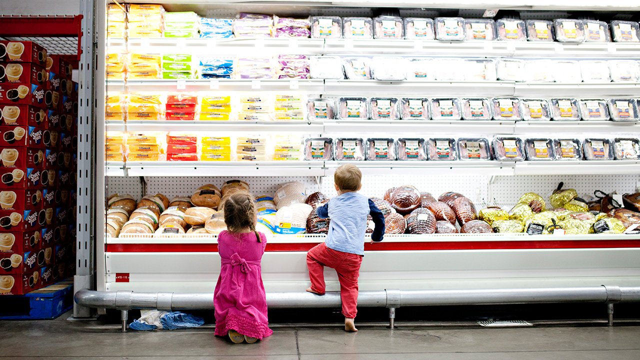 children in the meat aisle of supermarket