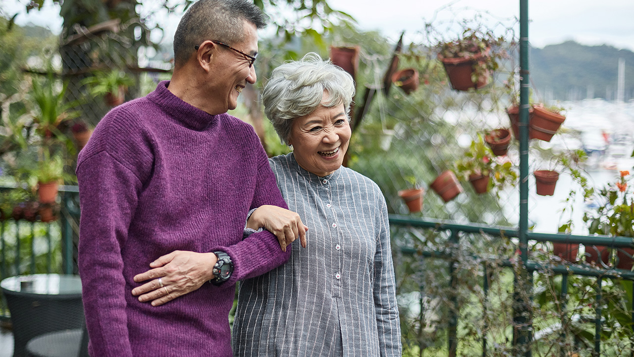 a mature couple is walking and hugging