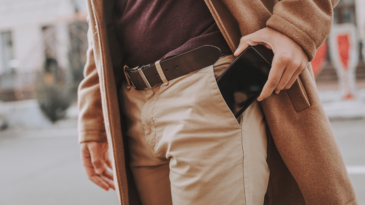 a man places a phone into his pocket