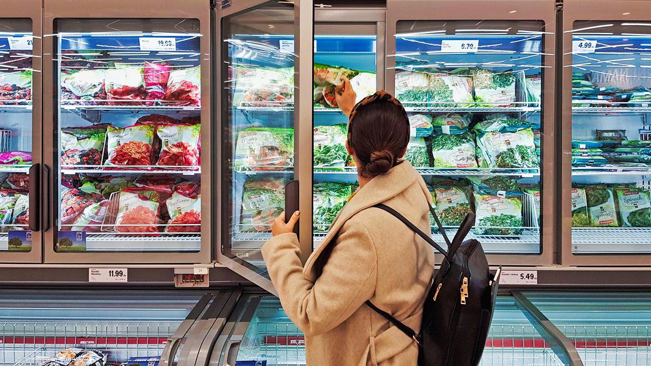 shopper in the frozen aisle of supermarket