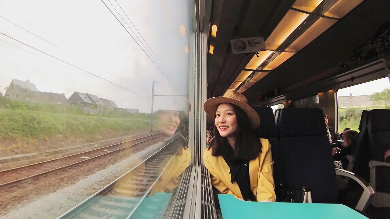 happy woman looks out a train window