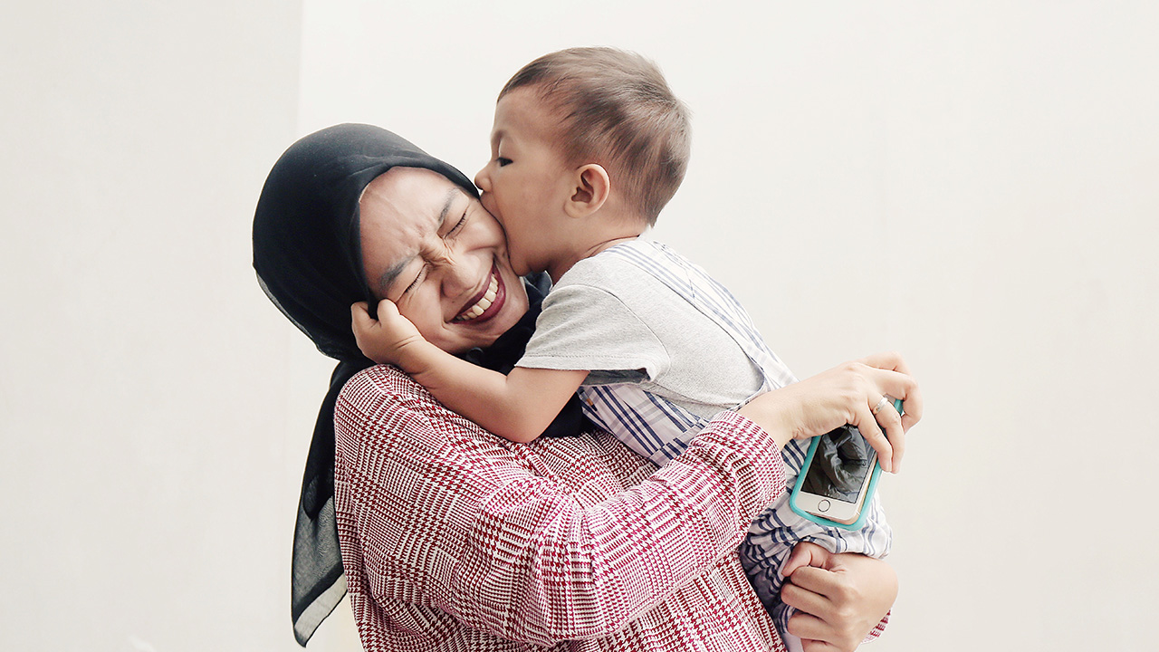 mom and child embrace and smile