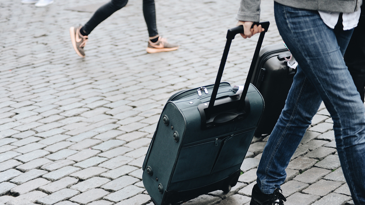 carrying suitcase through a city