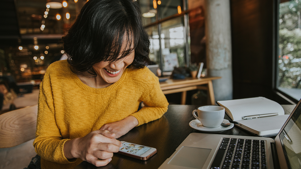 smiling person uses laptop