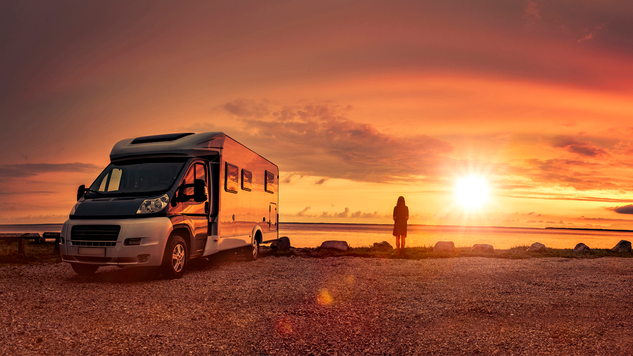 woman-with-rv-on-beach-sunset