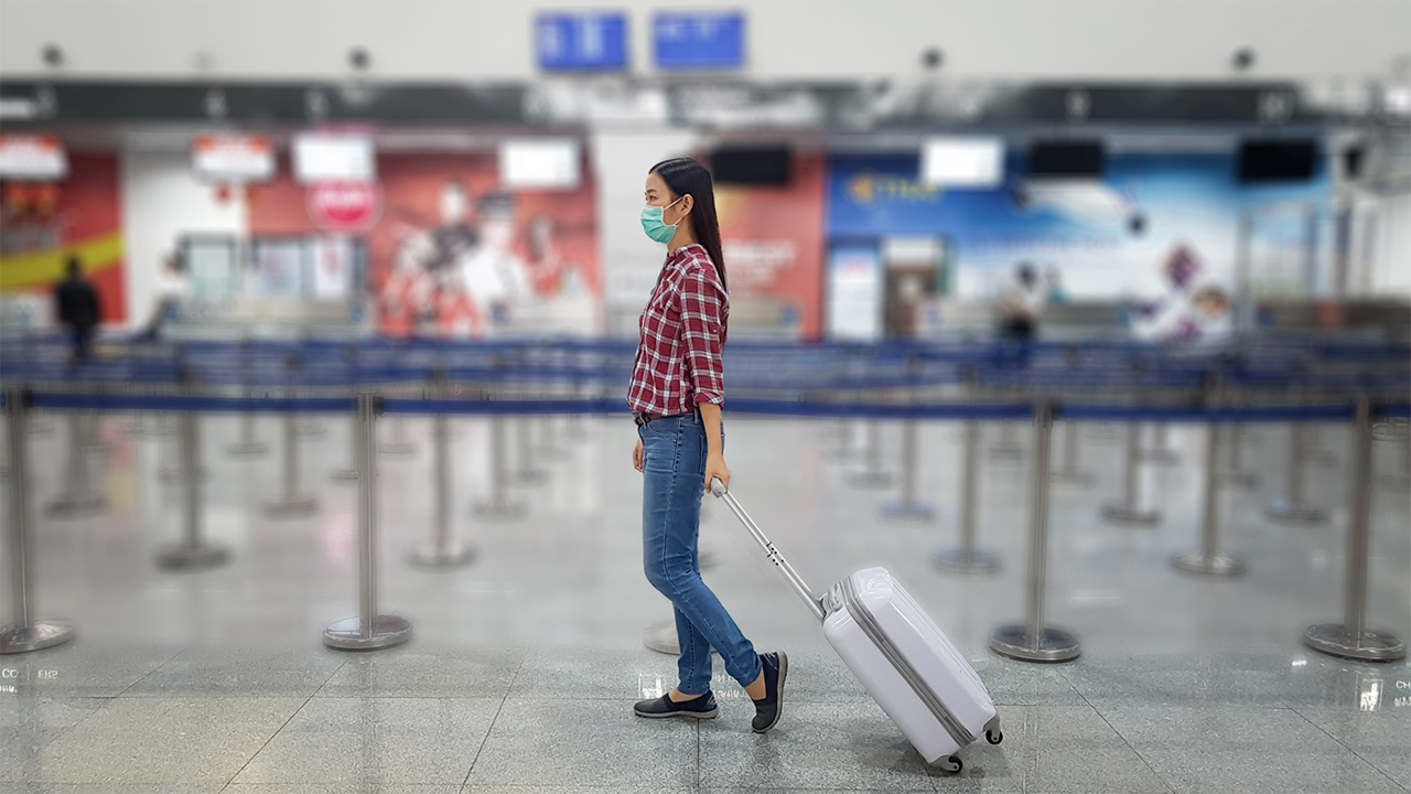woman-alone-in-airport-wearing-mask