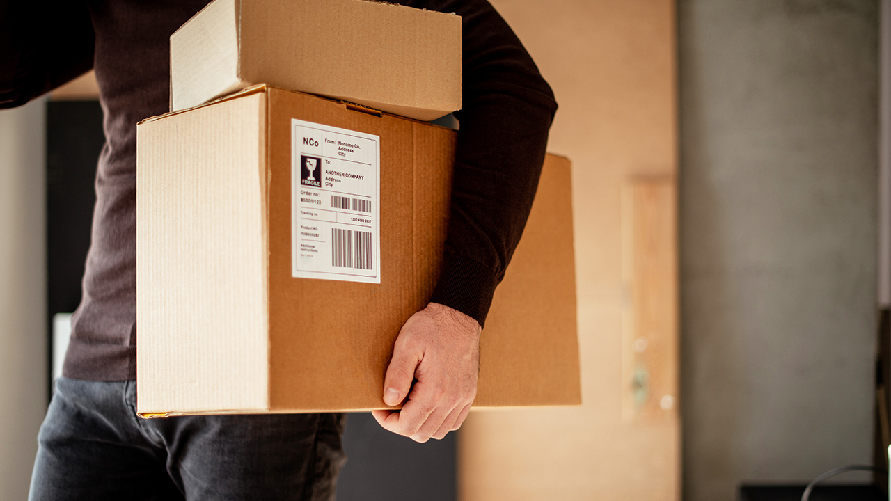 hero iStock-StockRocket young man carrying packages for shipment