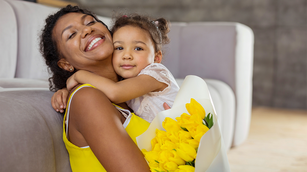 hero iStock-yacobchuk mom holding daughter flowers mothers day kids woman happy_