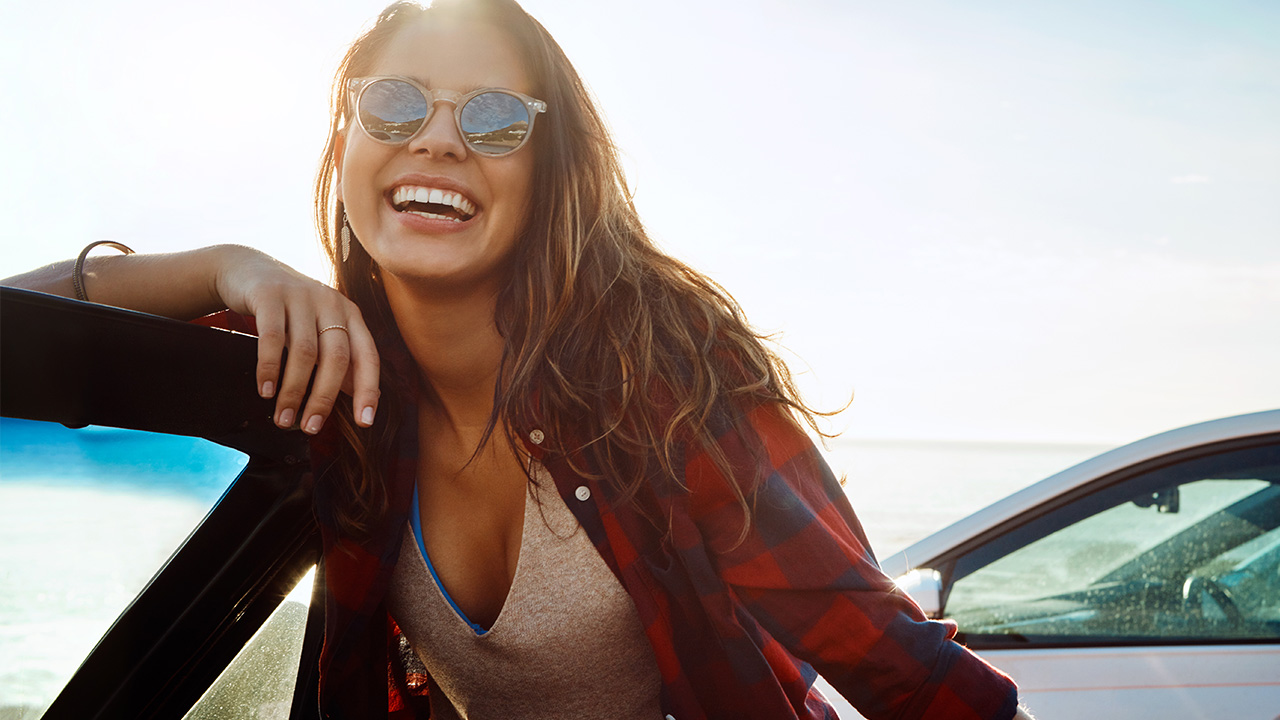 smiling near a car