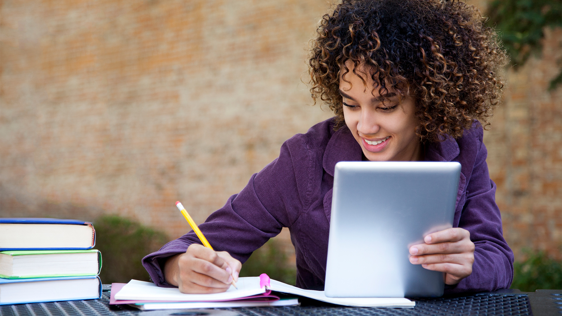 iStock-alejandrophotography woman ipad tablet college homework notes writing hero