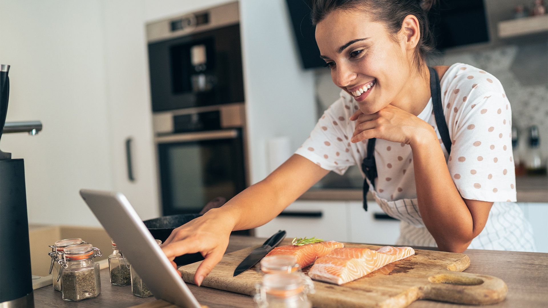 woman cooking salmon tablet kitchen hero