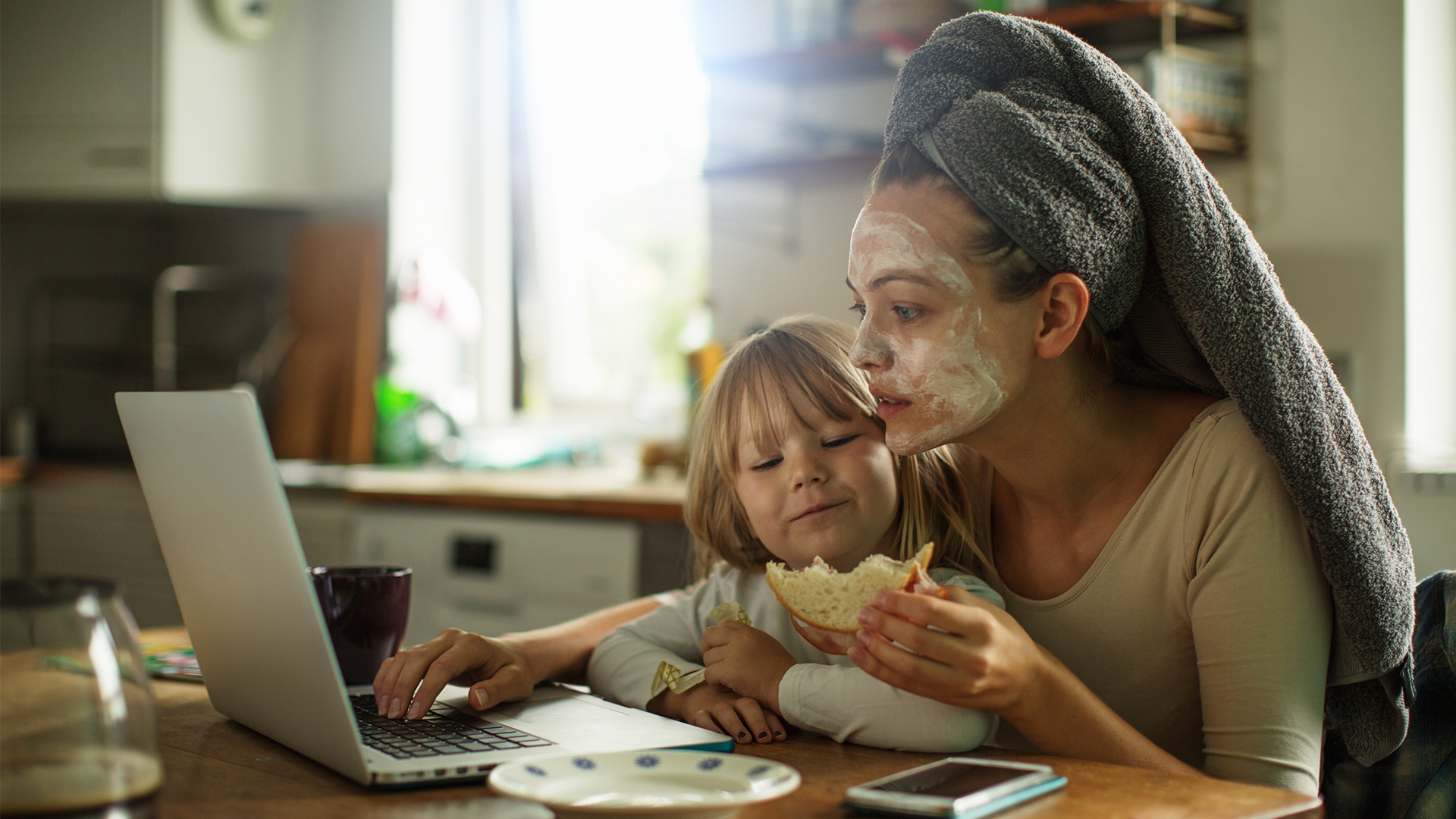 mom and child eating breakfast at computer