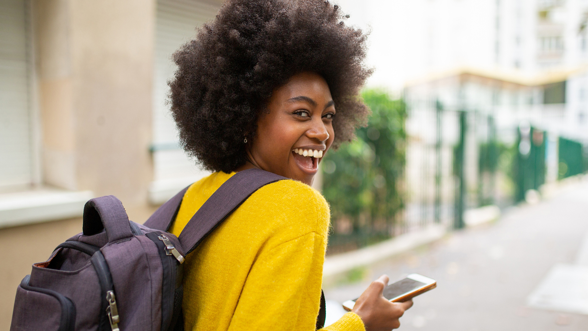 student looking back from phone smiling