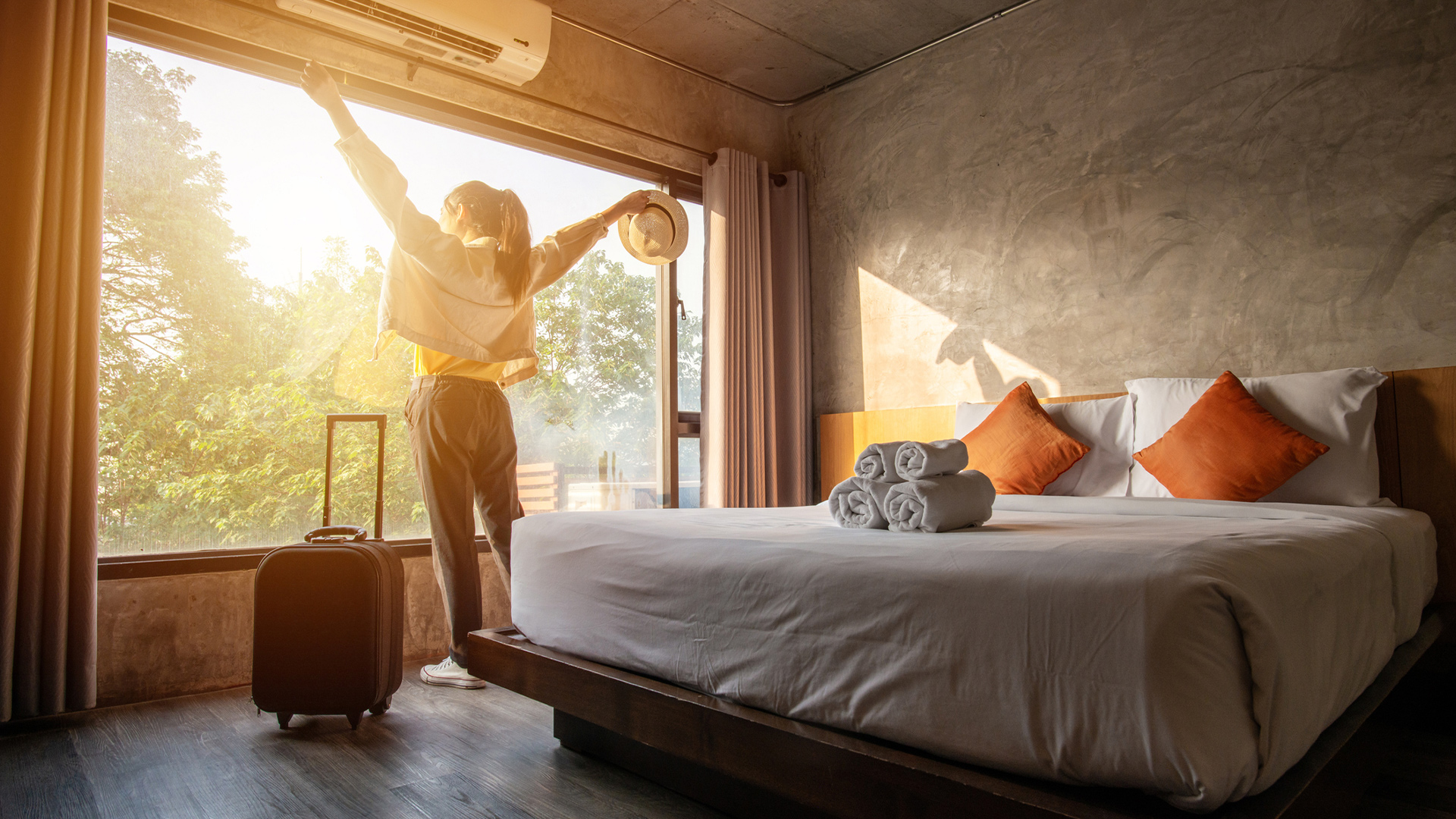 woman looking out window in hotel room