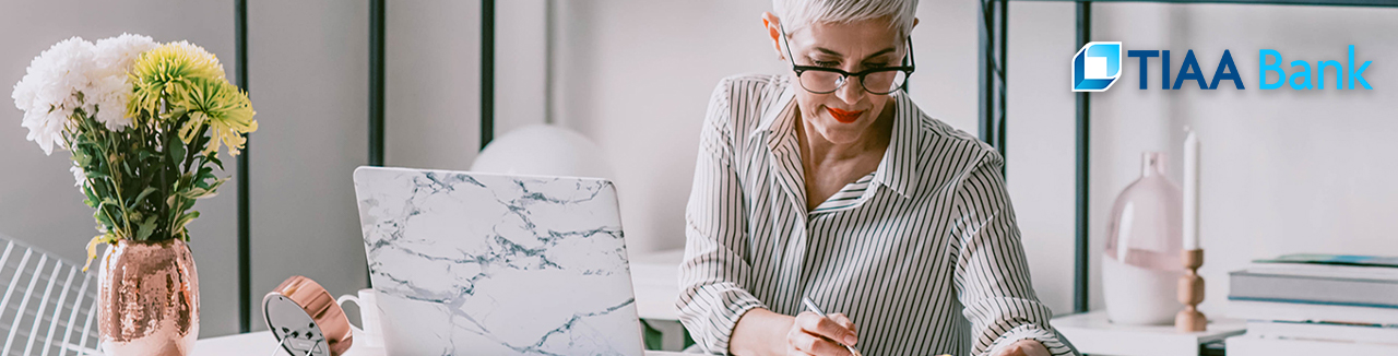 woman working at laptop with TIAA logo