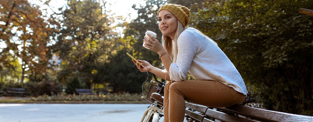 woman drinking coffee using phone