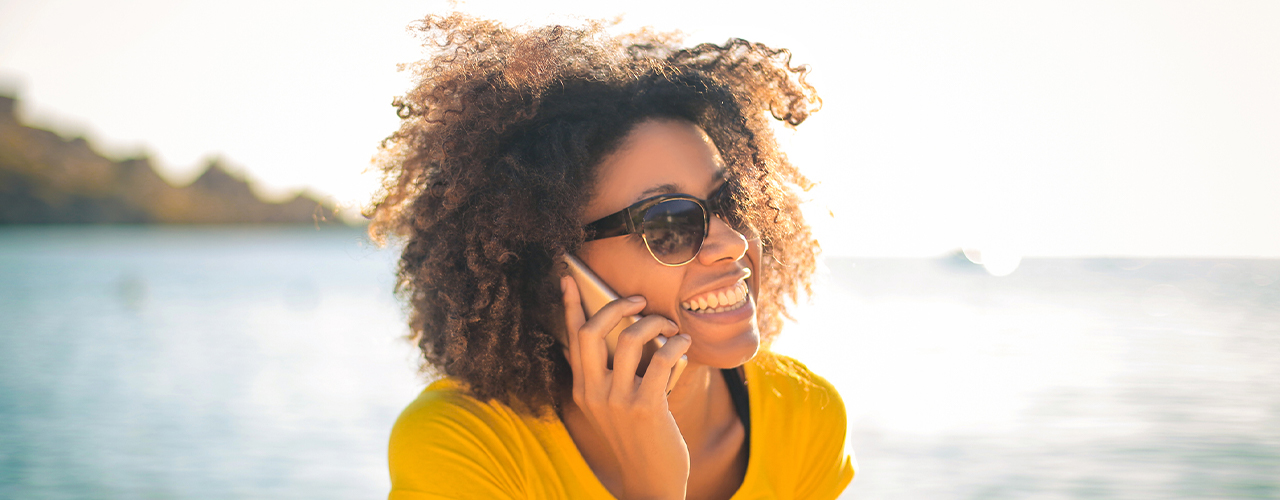 young woman using her smart phone at the beach