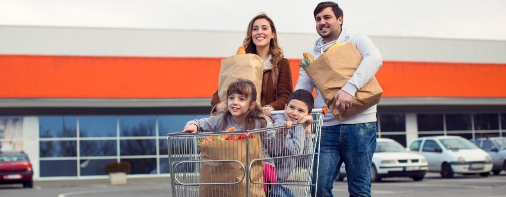family pushing grocery store cart