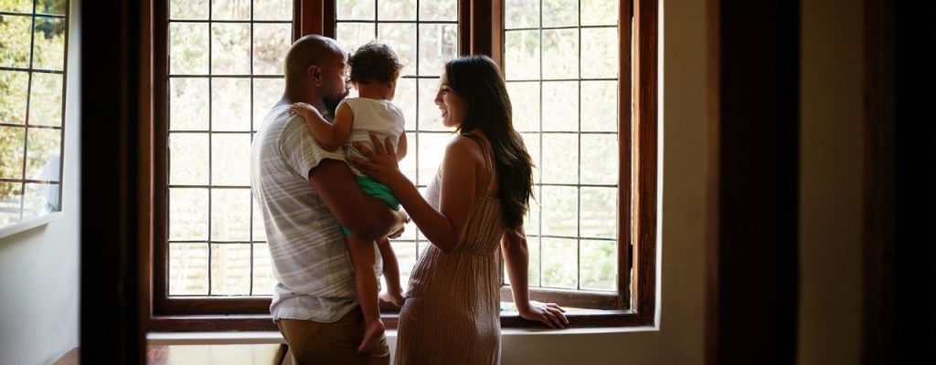family looking out of window in new house