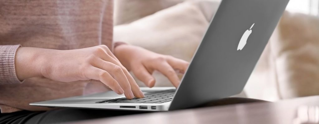 woman typing on macbook laptop