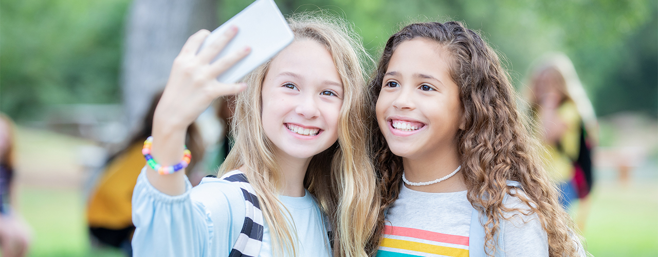 Preteen girls taking selfie together