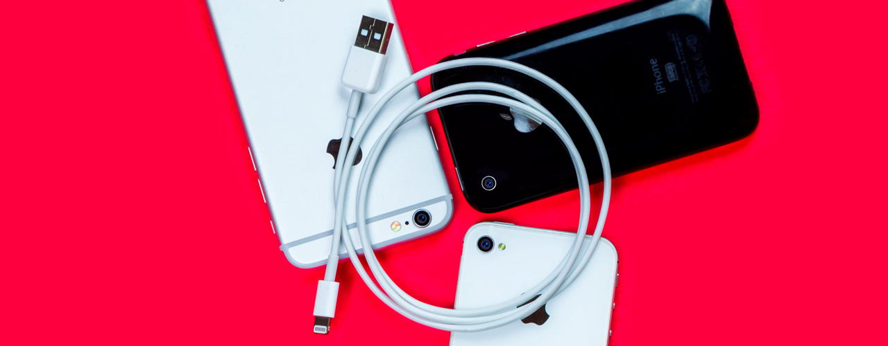 iphone lightning cable and iphones on red background