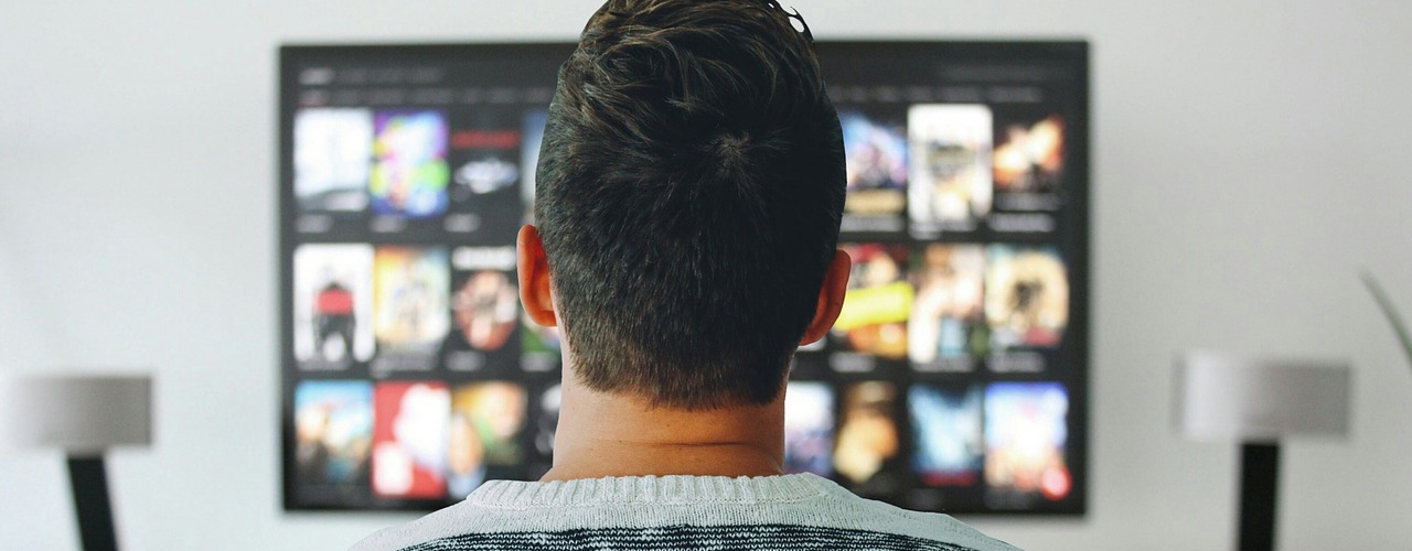 man sittting in front of tv on white wall