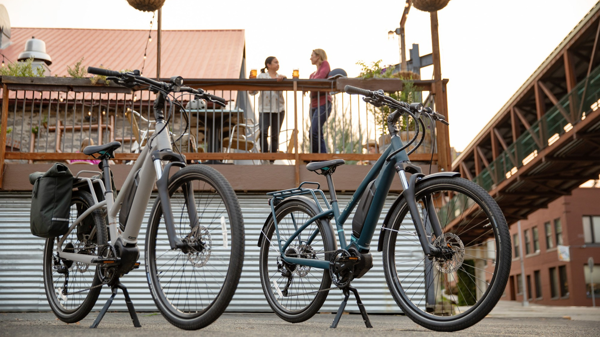 Co-op Cycles CTY e2.1 Electric Bike hero bikes parked in front of food on street