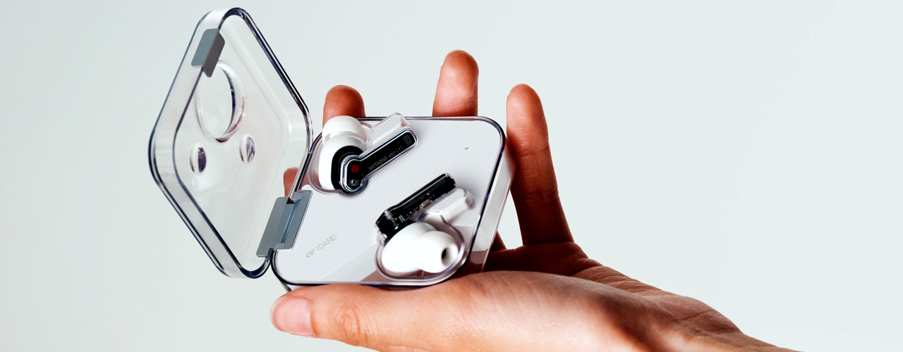 hand holding the nothing ear 1 wireless earbuds on grey background