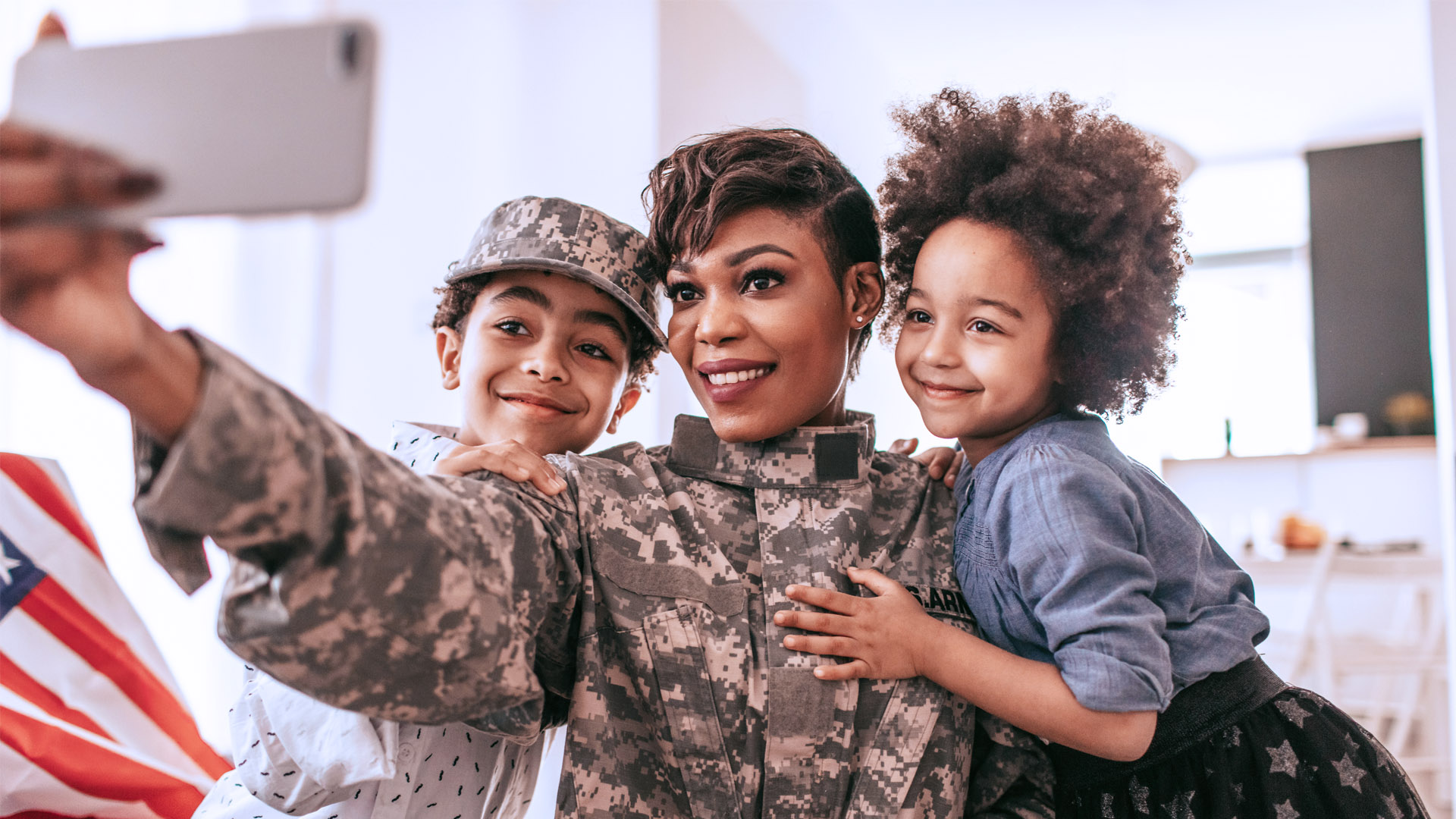 Military service woman taking a selfie with her two children.