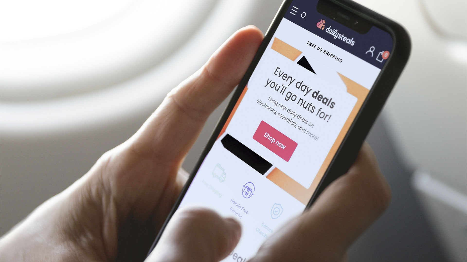close up of person holding smartphone with DailySteals website