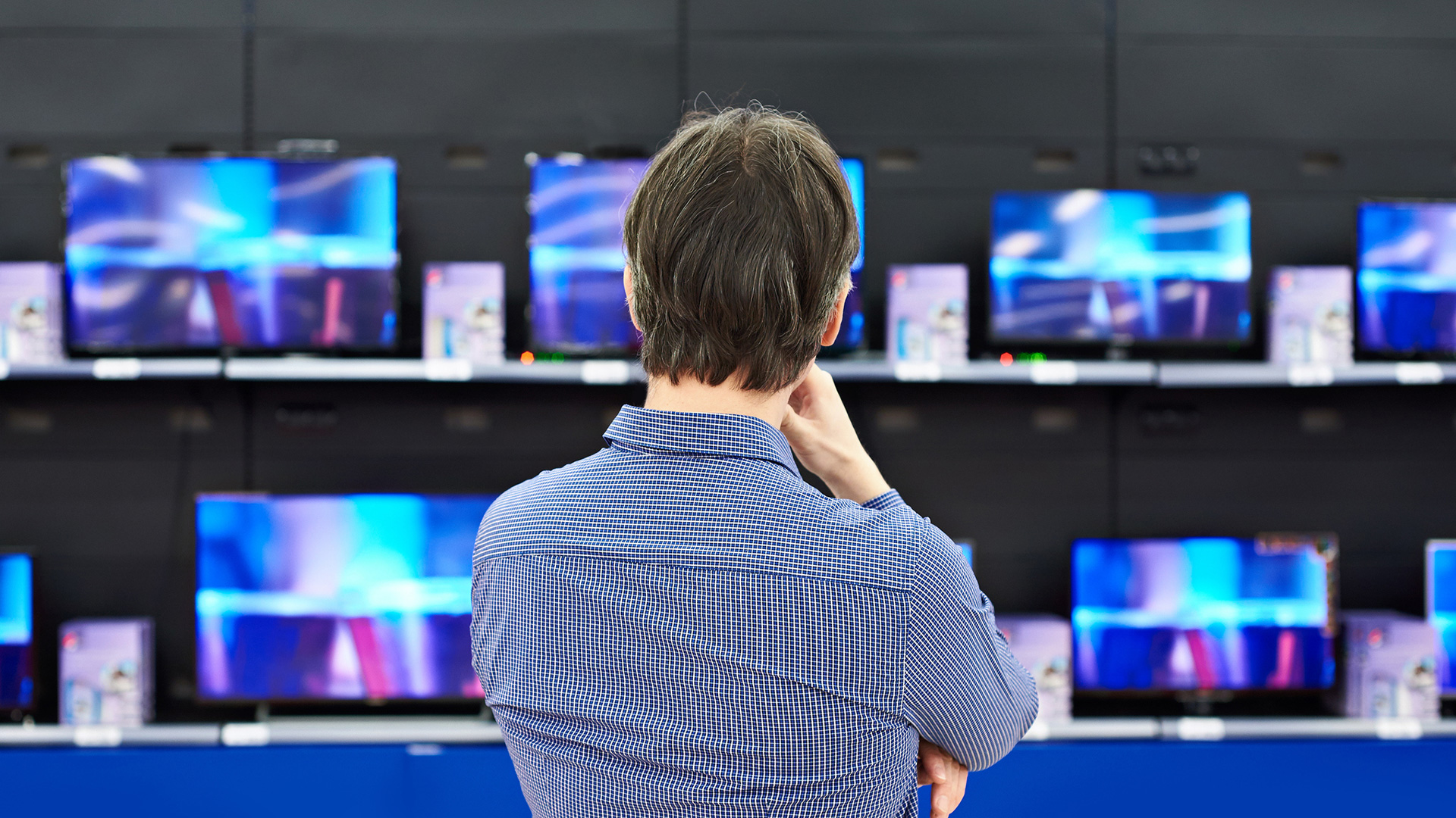 man shopping for tv in store