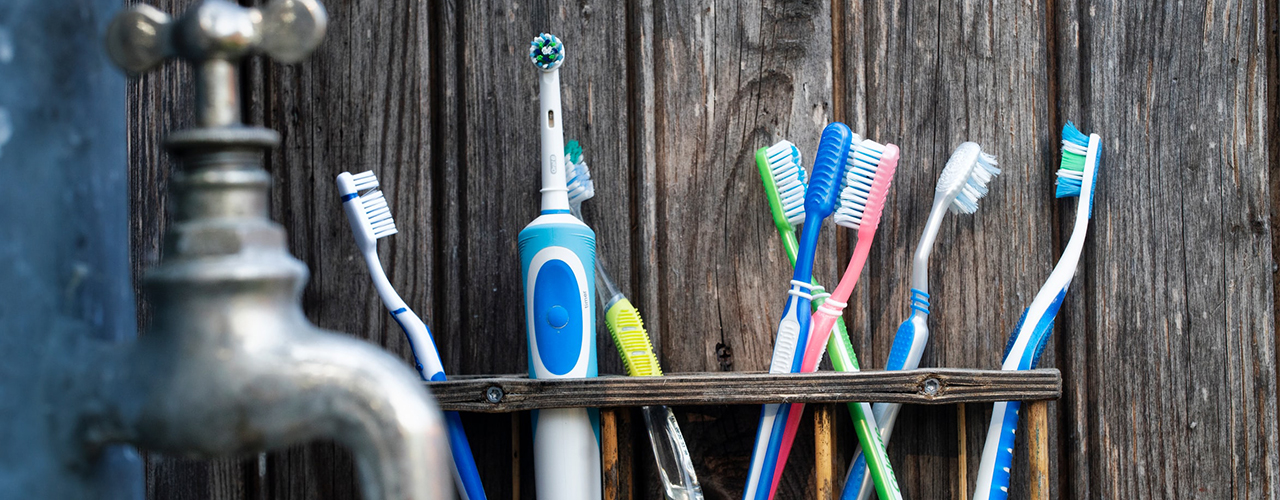 electric toothbrush on a shelf with manual brushes